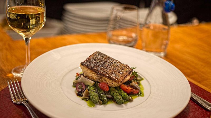Salmon entree on a bed of vegetables